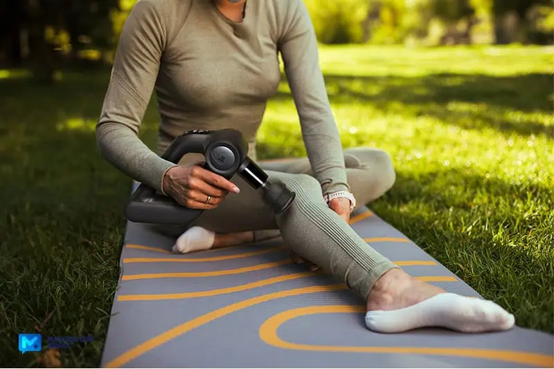 Bob and Brad D5 Pro Review: An Affordable Massage Gun For DOMs 18 bob and brad D5 Pro held by a lady on a yoga Matt outdoors