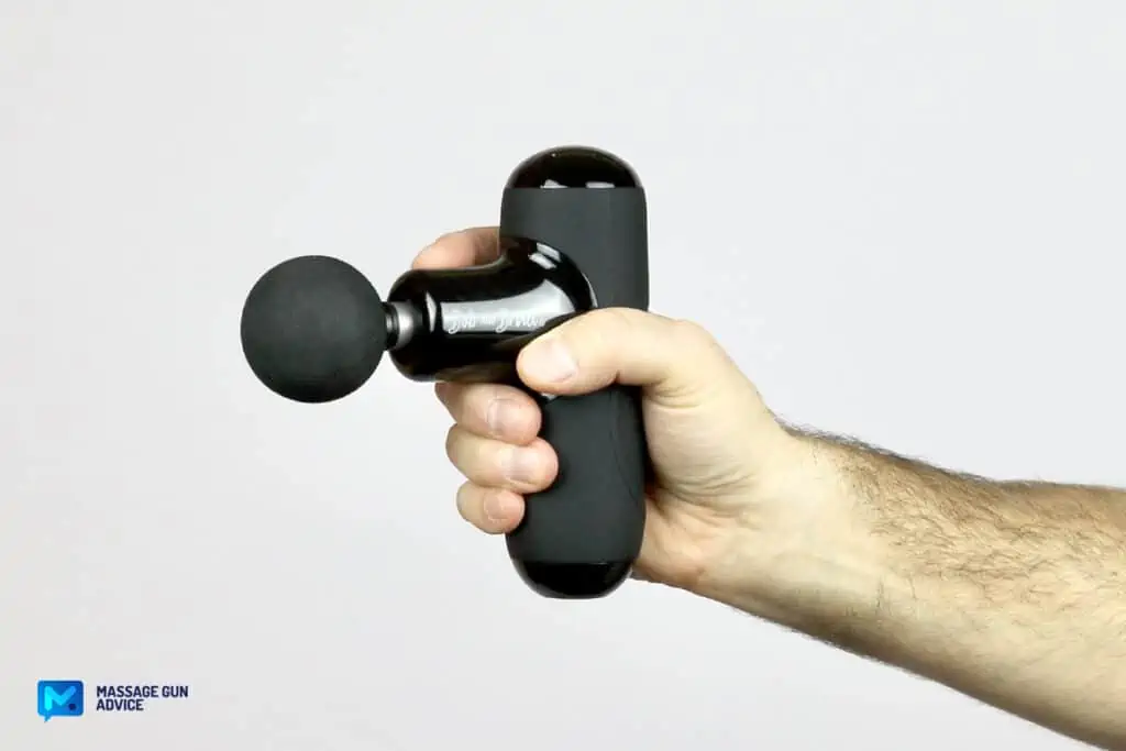 Massage Guns Made in USA - Are There Any at All? 32 a man's hand holding a mini-massage gun on a white background