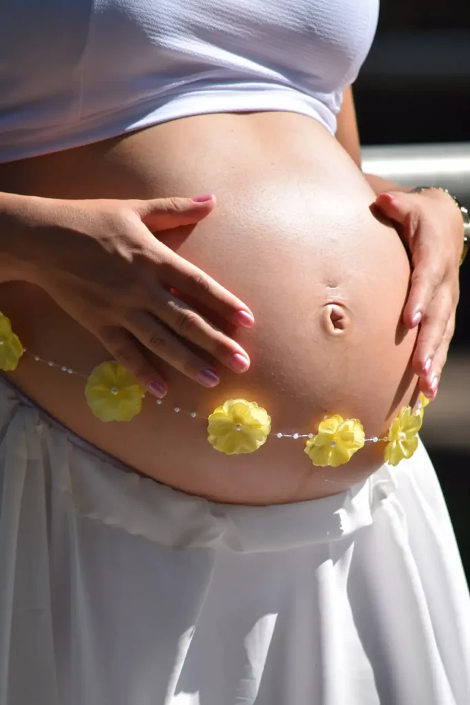 Can You Use a Massage Gun on Stomach? The DOs and DON'ts from our Physical Therapist 8 a pregnant woman holding with her hands her tummy