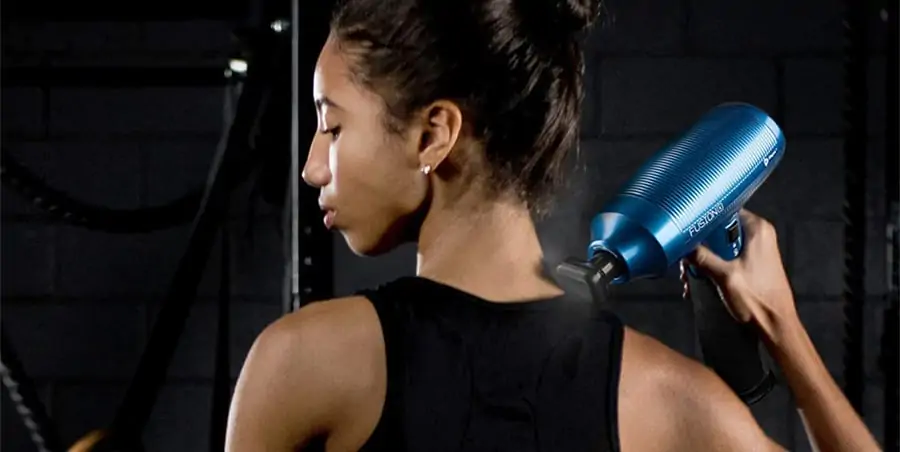 Massage Guns Made in USA - Are There Any at All? 27 the back a woman holding on her hand a lifepro fusion x heated massage gun against her trapezius.