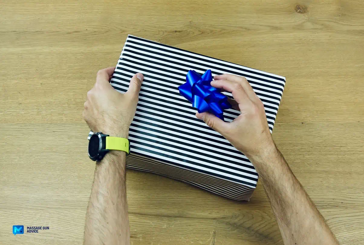 Tech Gifts: Are Massage Guns Good Gift Ideas? - Guide 2026 22 hands unwrapping gift. blue ribbon on top; valentines gift for her; gifts for father's day