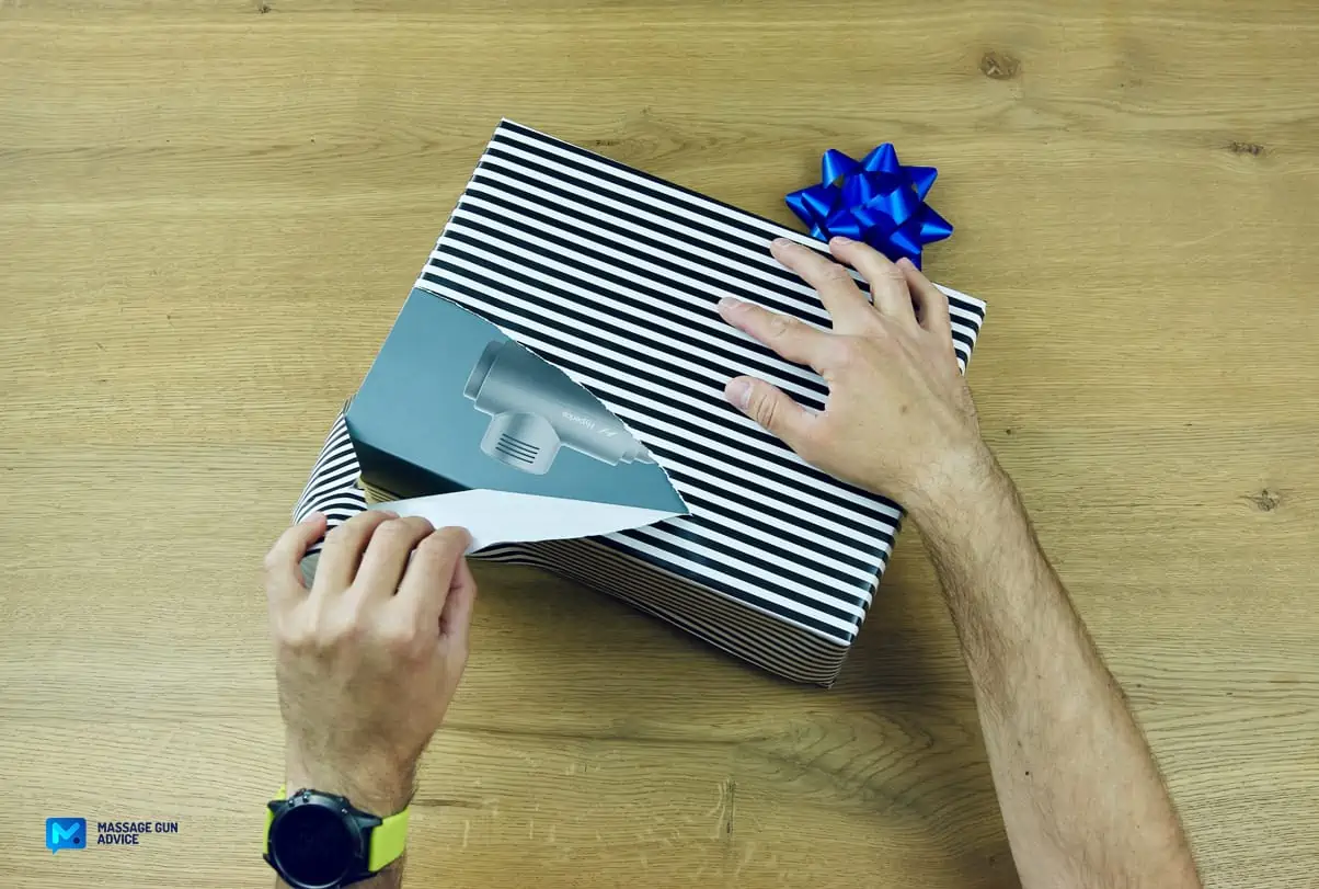 Tech Gifts: Are Massage Guns Good Gift Ideas? - Guide 2026 23 hand tearing off wrapping paper of gift; unique gifts for men;